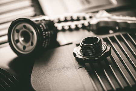 Mortor oil cap in engine room with oil filter and chain wrench in the background.の写真素材