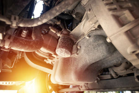 The oil filter installed on the motor, close up at an old oil filter. Car maintenance concept.
