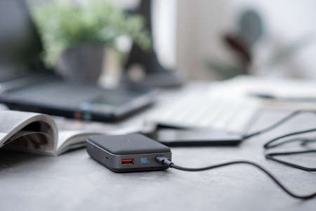 Smartphone battery charging with power bank. close-up at the grey power bank.の写真素材