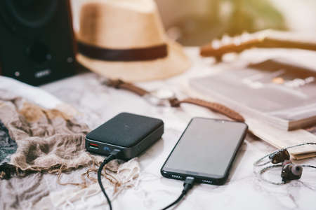 Smartphone battery charging with power bank. close-up at the grey power bank.の写真素材