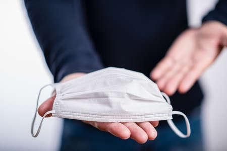The man giving you a face mask to protect yourself from Coronavirus disease (COVID-19).の写真素材