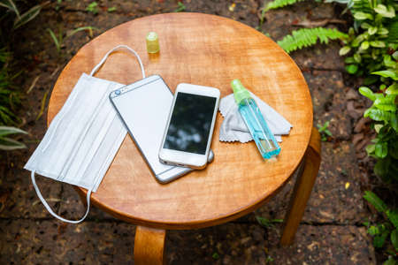 Cleaning the smartphone with soft cloth and alcohol. COVID-19 prevention concept.の写真素材