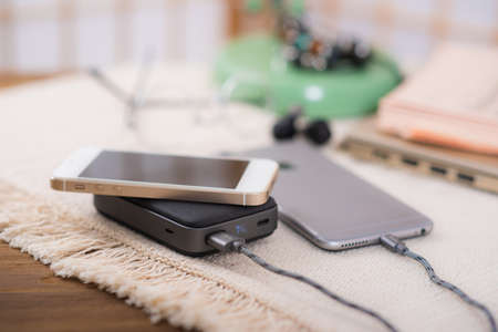 Smartphone battery charging with power bank. close-up at the grey power bank.の写真素材