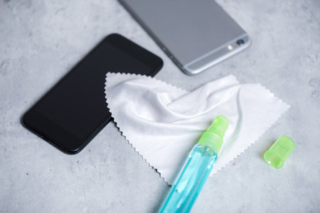 Cleaning the smartphone with soft cloth and alcohol. COVID-19 prevention concept.の写真素材