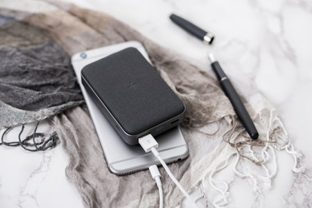 Smartphone battery charging with power bank. close-up at the grey power bank.