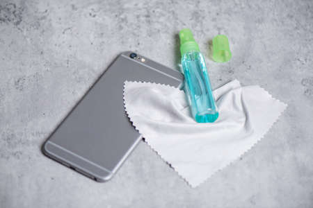 Cleaning the smartphone with soft cloth and alcohol. COVID-19 prevention concept.の写真素材