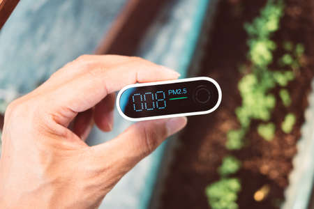 Close up portable air quality monitor detect PM 2.5, the low level is good air quality.の写真素材