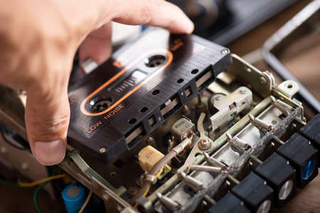 Technician repairing an old radio cassette recorder.