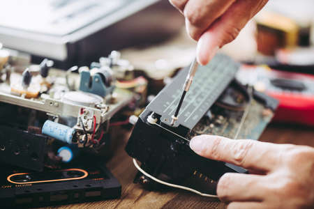 Technician repairing an old radio. Radio repair and restoration concept.の写真素材