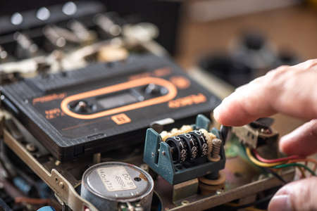 Technician repairing an old radio cassette recorder.の写真素材