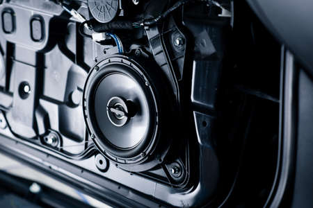 Close up the speaker on the car door during installation. Car audio installation concept.