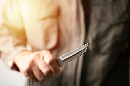 The man holding a pocketknife with Tanto blade in hand.