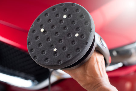 DA polisher with foam pad over the red car. Car detailing concept.
