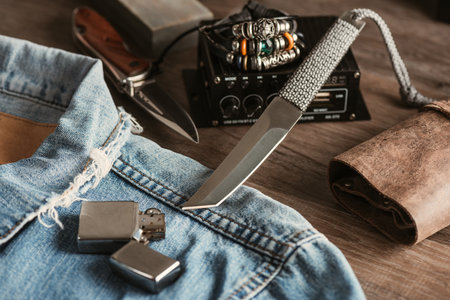 Close up stainless steel pocketknife and lighter on denim jacket. EDC (Every Day Carry) for men.の写真素材