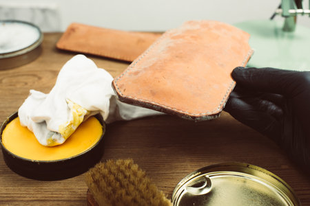 The man cleaning mould on leather product. Leather care concept.