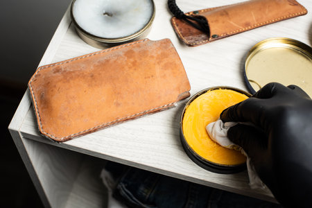 The man cleaning mould on leather product. Leather care concept.