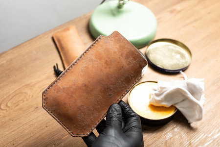 The man cleaning mould on leather product. Leather care concept.