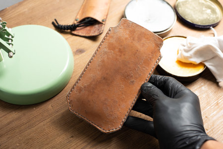 The man cleaning mould on leather product. Leather care concept.