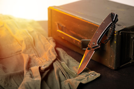 stainless steel pocketknife with military objects in the background.
