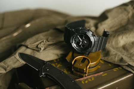 Close up black analog-digital hybrid wristwatch. Military style men watch with military objects.の写真素材