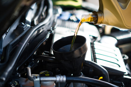 Pouring clean new engine oil to the car motor.の写真素材