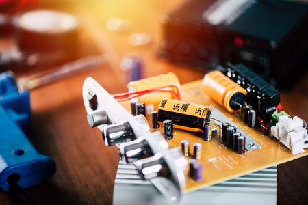 Technician repairing the electronic device. Reparing the audio amplifier. Close up at the orange capacitor.の写真素材