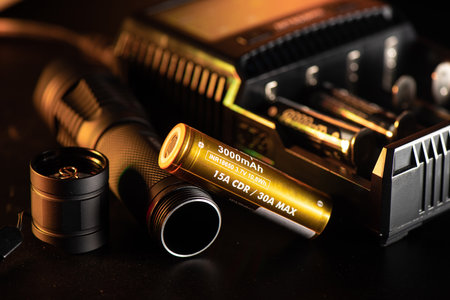 Close up the golden INR18650 3.7V rechargeable battery with charger. INR18650 battery is Lithium...