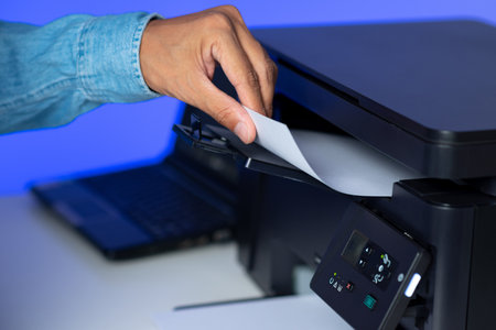 The man using multi-function laser printer in the home office.の写真素材