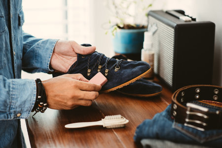 The man cleaning the blue suede shoes. Shoe care concept.の写真素材