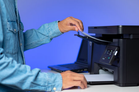 The man using multi-function laser printer in the home office.の写真素材