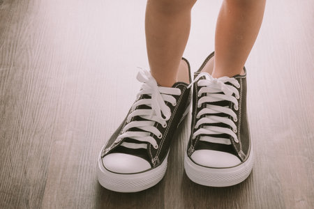 Baby wearing the big black and white canvas sneakers.