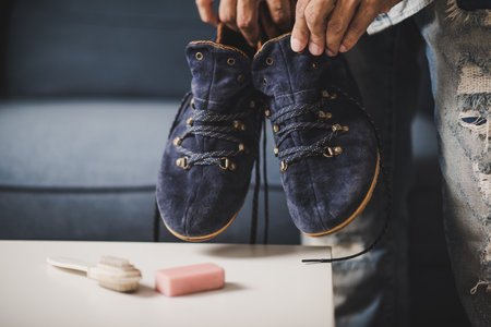 The man cleaning the blue suede shoes. Shoe care concept.の写真素材