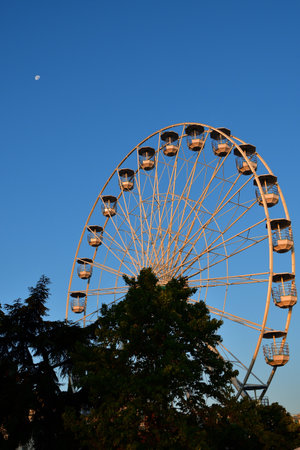 Switzerland, Geneva. Early morning moon and Ferris wheel. August 16, 2022.の写真素材