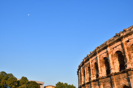 Early Morning View of the NÃ®mes Arena with the Moon â€” NÃ®mes, France, 13 August 2025