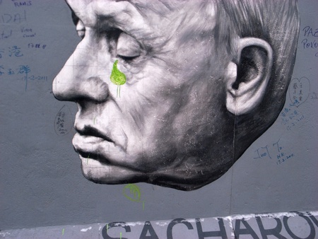 berlin,germany,20 february 2011: one of the murals of the berlin wall. the head of a man, like a statue, with distraught expression; a green tear from his left eye is getting ready to sail the face.のeditorial素材