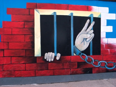 berlin germany, 20 february 2011: berlin wall, they are exposed as works of art in a large open-air exhibition. we see two hands get out from of the prison bars; the left hand is raised to the sky, with a chain to the wrist, making the gesture of victory.のeditorial素材