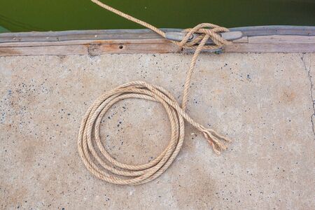 Boat docking point at a marina - rope fixed around a belay in a small harbor