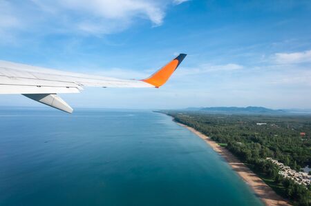 Airplane taking off from the island with long beach underneathの写真素材