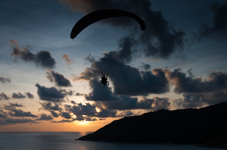 Paraglider flying at the sunset time at the shore of Phuket Thailandの写真素材