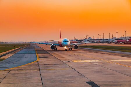 Airplane ready to taking off runway at the sunset time in the eveningの写真素材