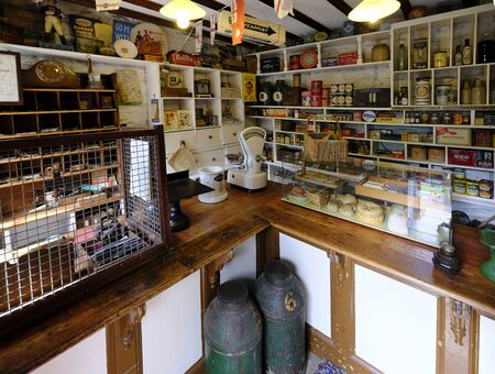 19 Aug 2018: Ryedale Folk Museum, Hutton le Hole, North Yorkshire, UK. Interior of a mid 1900s sub post office and grocery store. Shelves stacked with goods, wire mesh protects the postal service.のeditorial素材
