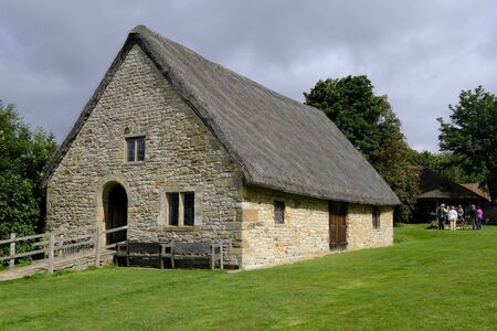 19 Aug 2018: Ryedale Folk Museum, Hutton le Hole, North Yorkshire, UK. Manor House rises above all around. Set in green grass, with a wooden ramp to its entrance. A group gather in the background.のeditorial素材