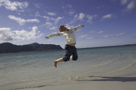 Girl jumping on Lofoten beach in Norwayの写真素材