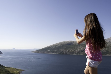 Girl photographing fjord in Norway の写真素材