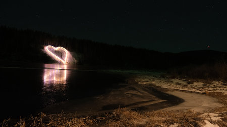 Winter landscape in the night in Christmas time, cowered by  snow heart of lightの写真素材