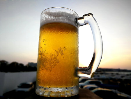 bubbles in the beer in the glass. the beer is poured into a beer glass and it flows in foam in a...