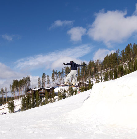 Young man jumping with a snowboardの写真素材