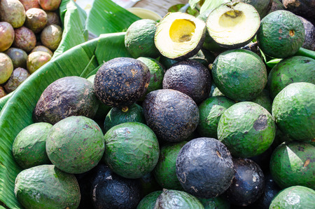 Avocado in bowl lined with banana leafの写真素材