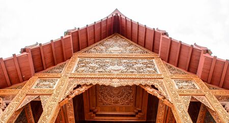 Carved wooden front of Thai Temple roofの写真素材