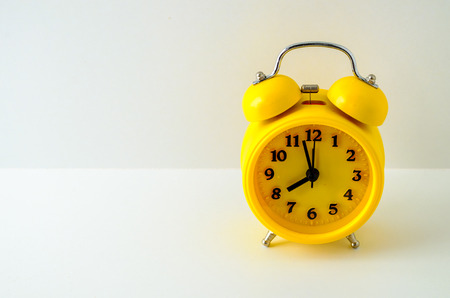 Yellow alarm clock against a white backgroundの写真素材